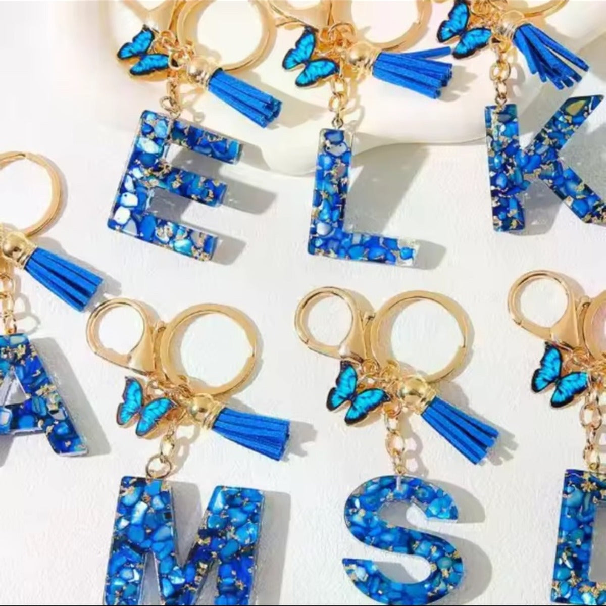 Blue butterfly tassel initial keychains in multiple letters