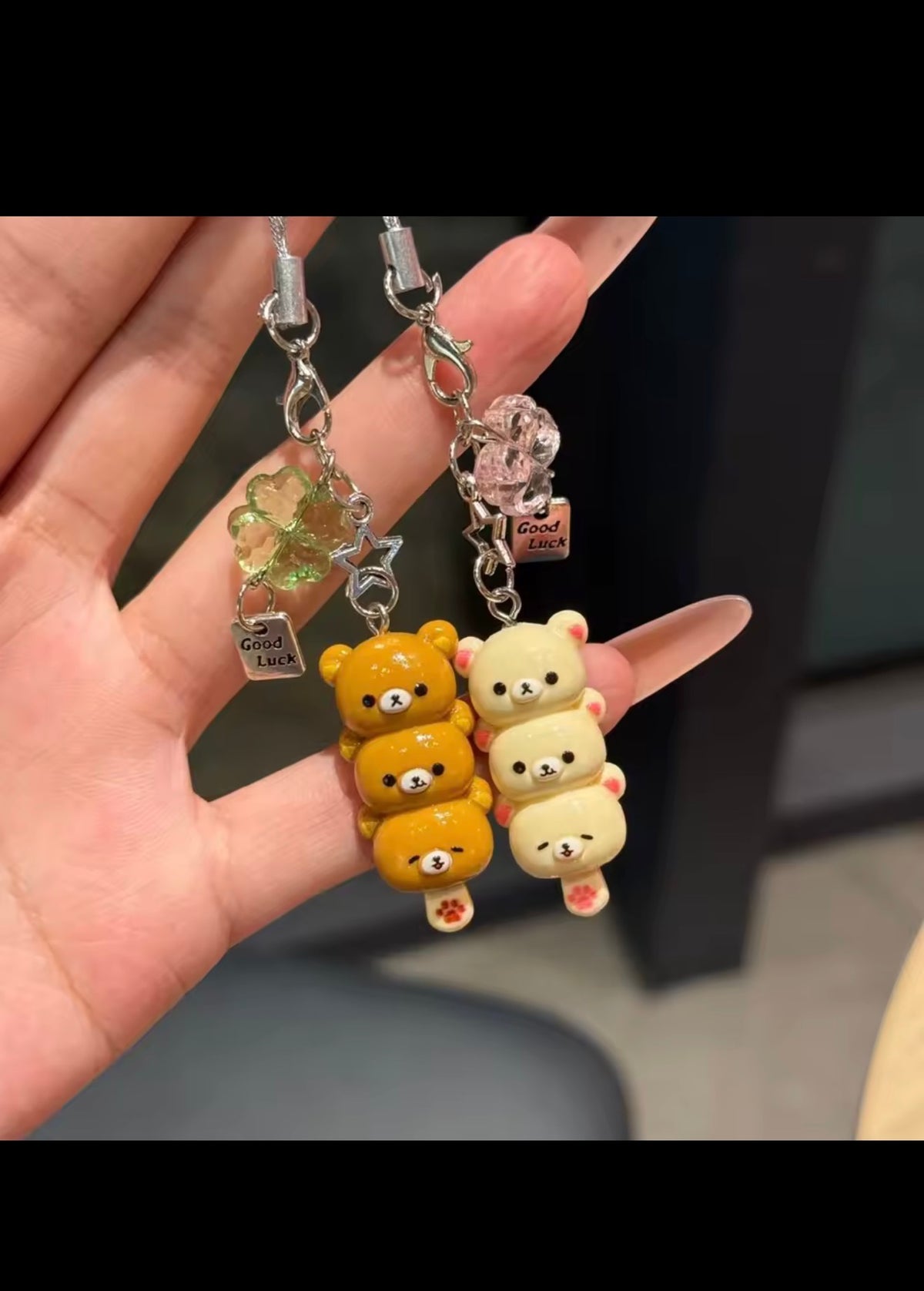White and brown bear phone charms held in hand