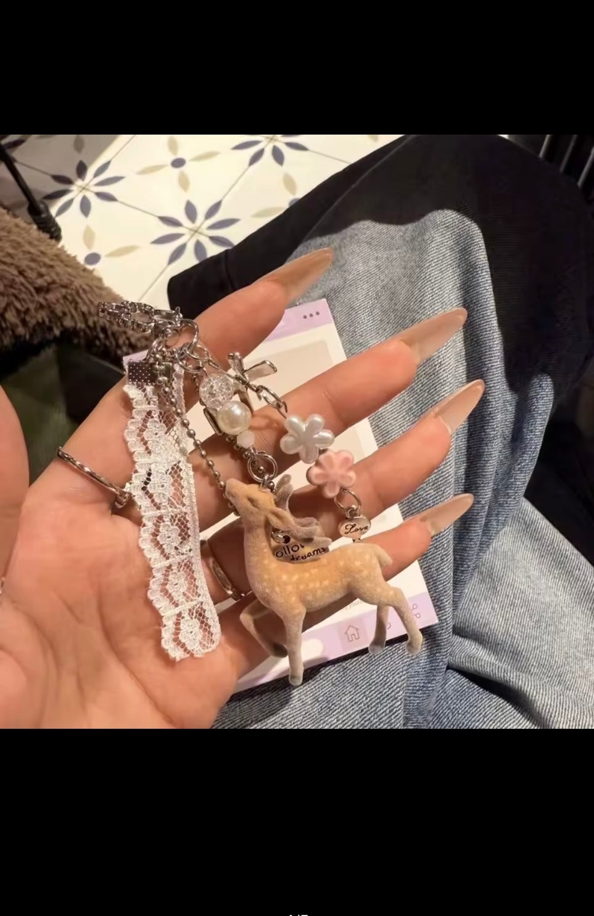 Deer lace charm keychain shown in hand