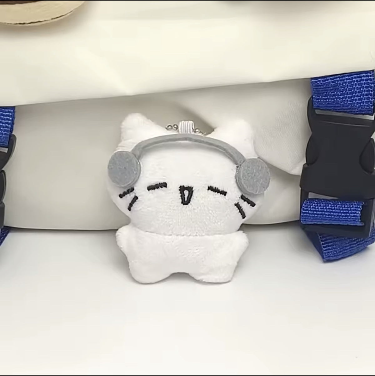 White plush kitten keychain with grey headphones